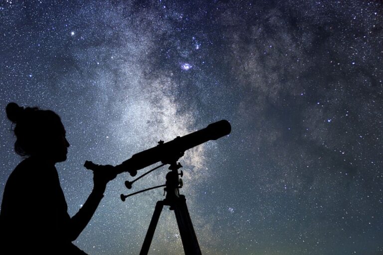 woman with telescope stargazing starry sky (stock image)